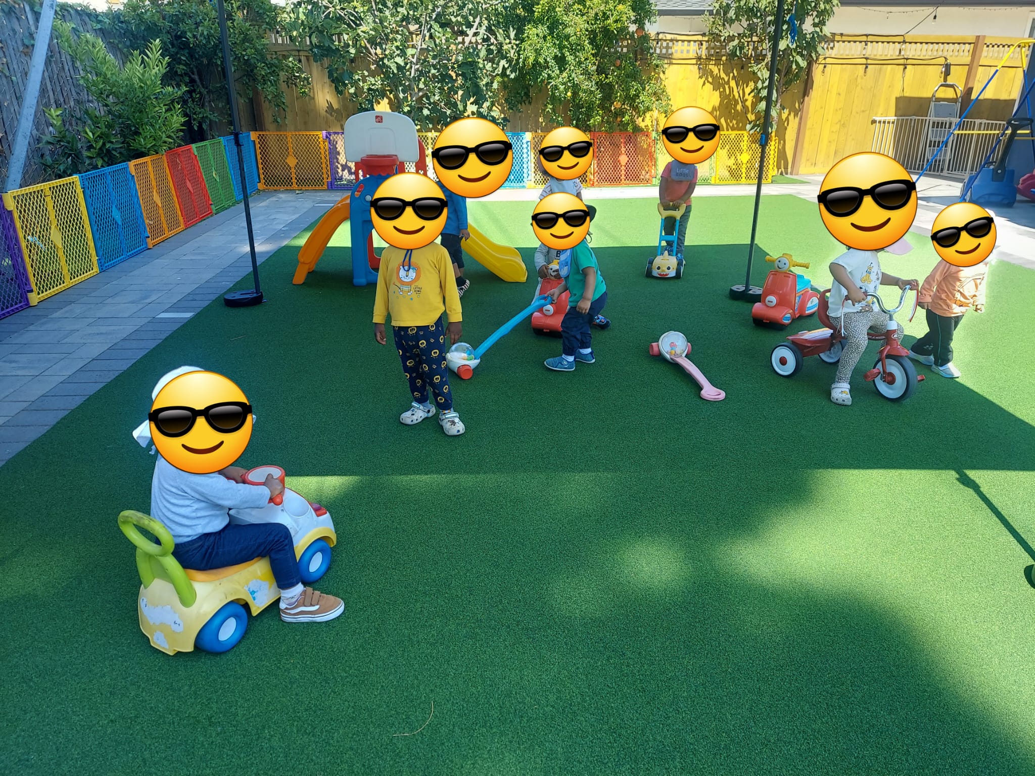 Colorful outdoor daycare play area with slides and riding toys