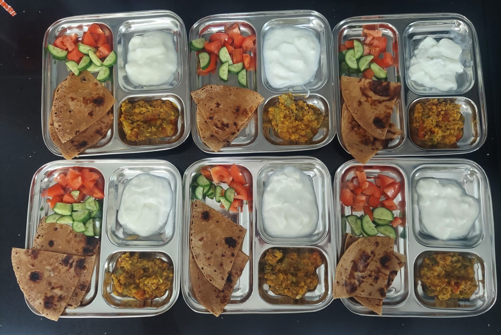 Fresh vegetarian meals portioned into lunch plates for children